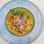a bright, flavorful curry served with fresh greens and sliced peppers