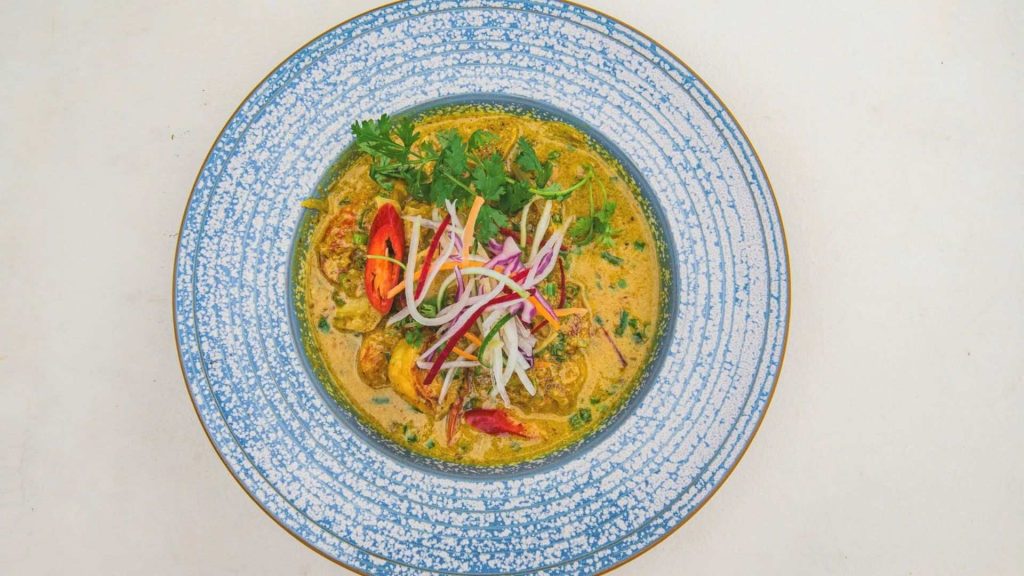 a bright, flavorful curry served with fresh greens and sliced peppers